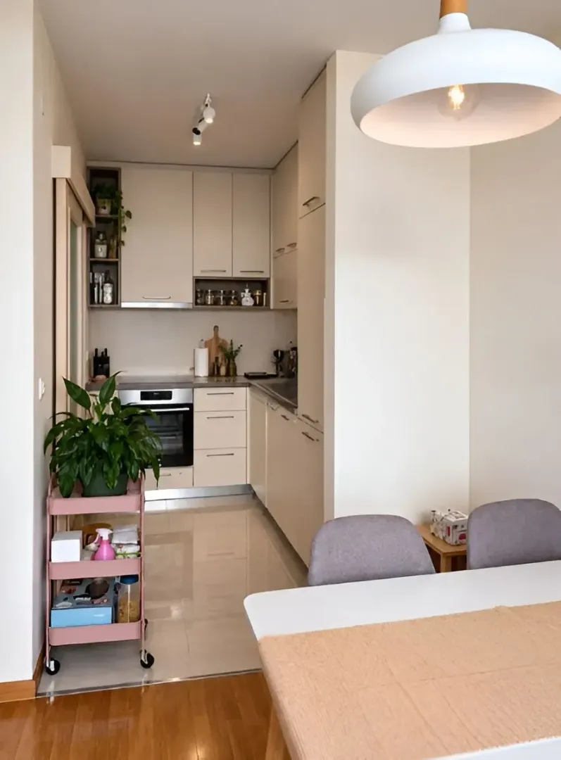 Modern kitchen with a dining table and light-colored cabinetry.