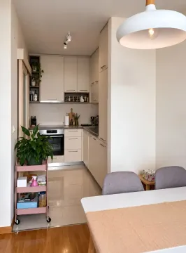 Modern kitchen with a dining table and light-colored cabinetry. - image 3