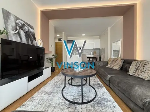 Dnevna soba sa garniturom, TV-om i pogledom na kuhinju u pozadini. - image 9