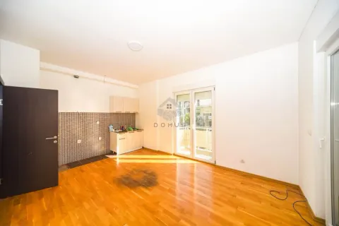 Small kitchen with wooden units within a bright living area. - image 3