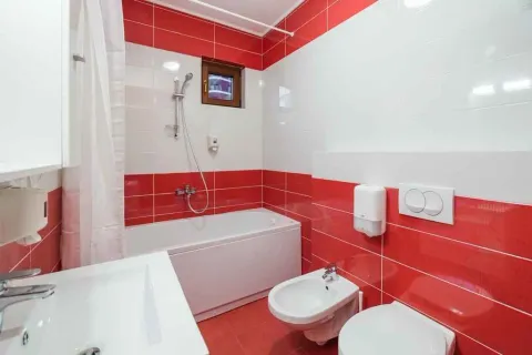 Kupatilo sa kadom, umivaonikom i sanitarijama u crveno-bijelim pločicama. - image 7
