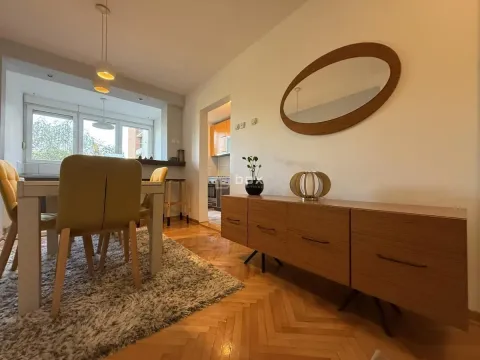 Dining area with a table and chairs, connected to the living room and the kitchen in the background. - image 5
