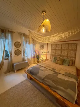 Spacious bedroom with a double bed, wooden ceiling, and decorative lighting. - image 3