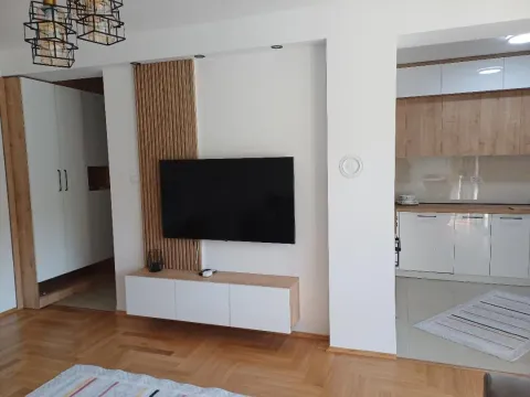 Living room with a TV and a view of the kitchen. - image 3