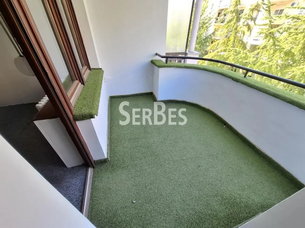 Manji polukružni balkon obložen veštačkom travom.