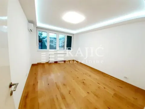 Prazna soba sa parketom i spuštenim plafonom sa rasvetom. - image 6