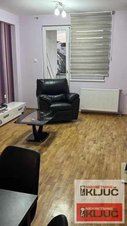 Dnevni boravak sa garniturom i izlazom na terasu.