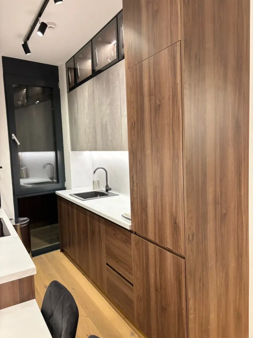 Modern kitchen with wooden elements and built-in lighting.