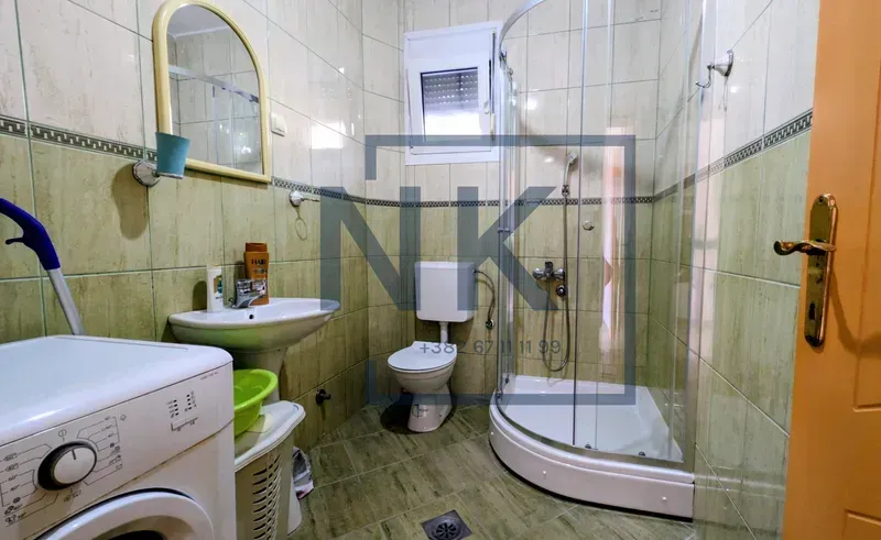 Kupatilo opremljeno tuš kabinom, umivaonikom, wc šoljom i veš mašinom.