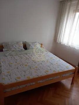 Spavaća soba sa drvenim krevetom i prozorom prekrivenim zavesama. - image 7