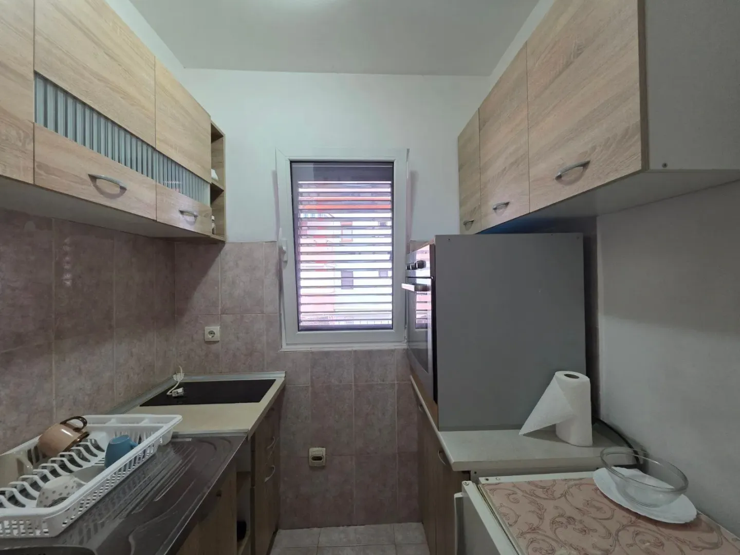 Smaller kitchen with wooden cabinetry and a window at the end of the room.