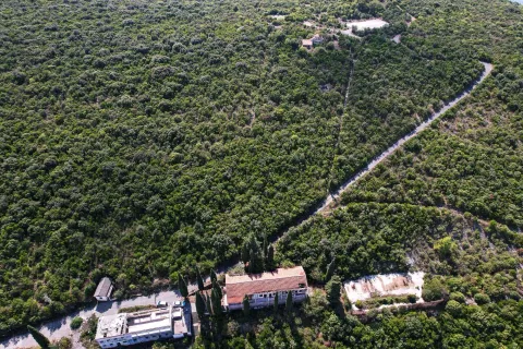 Pogled iz vazduha na imanje sa objektima okruženim zelenilom i šumom. - image 29