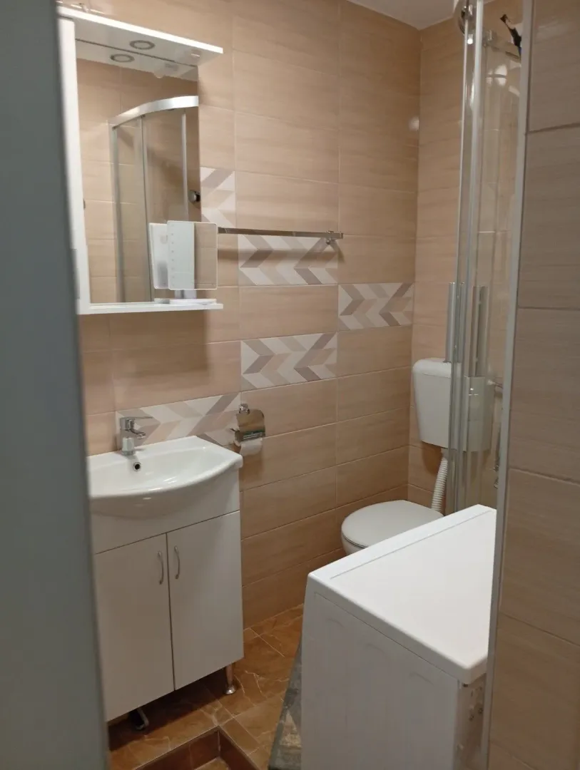 Svijetlo kupatilo sa lavaboom i veš mašinom.