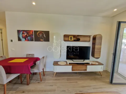 Dnevni boravak sa trpezarijom, TV komodom i modernim slikama na zidu. - image 7