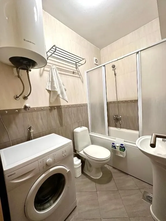 Funkcionalno kupatilo sa kadom, veš mašinom i bojlerom.