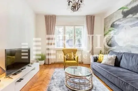 Furnished living room with a sofa, TV, and coffee table. - image 3
