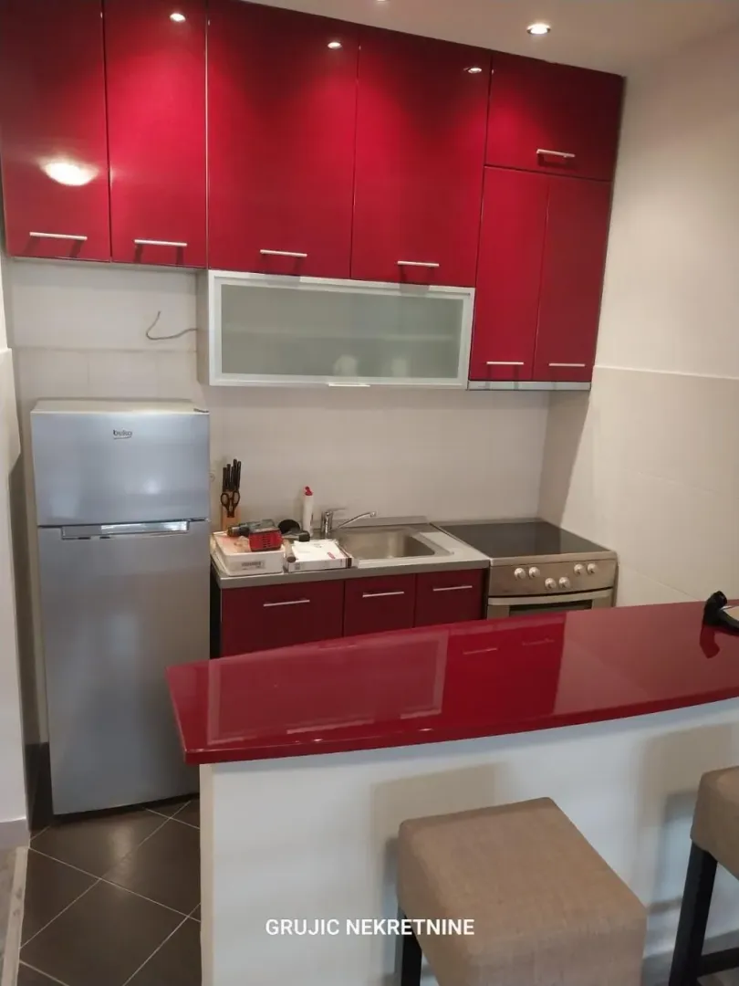 Smaller kitchen with red cabinets and a breakfast bar.
