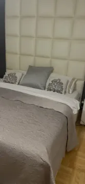 Pogled na bračni krevet sa tapaciranim uzglavljem u spavaćoj sobi. - image 7