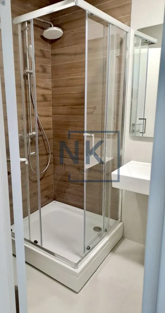 Bathroom with a shower cabin, washbasin, and mirror.