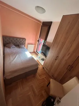 Spavaća soba sa bračnim krevetom, drvenim ormanom i izlazom na terasu. - image 9