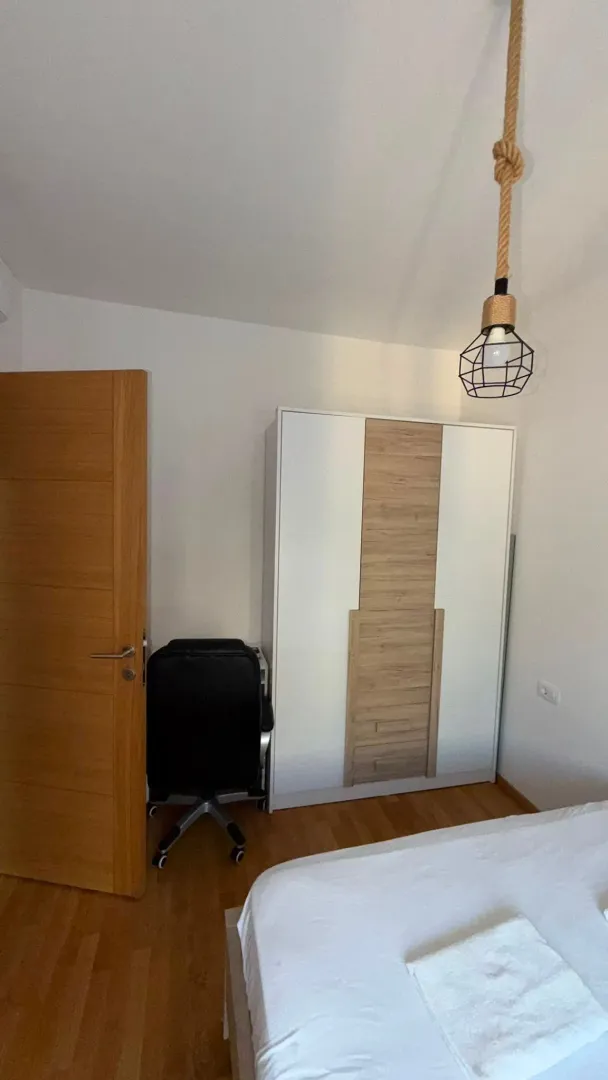 Small bedroom with a bed, wardrobe, and office chair.