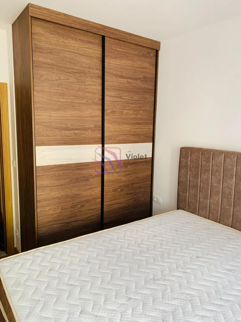 Bedroom with a double bed and a large wooden wardrobe.