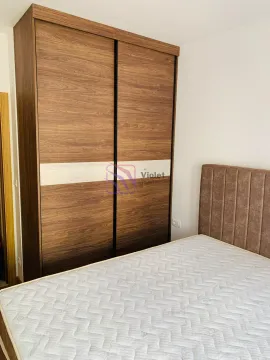 Bedroom with a double bed and a large wooden wardrobe. - image 4