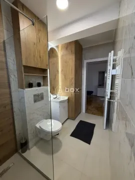 Savremeno opremljeno kupatilo sa tuš kabinom, konzolnom šoljom i drvenim elementima. - image 15