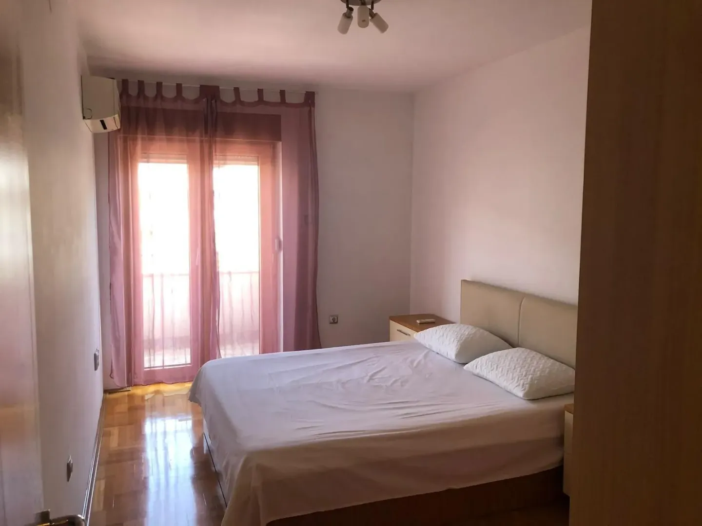 Spavaća soba sa bračnim krevetom i izlazom na terasu.