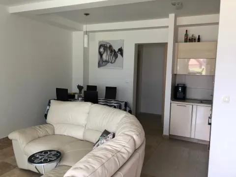 Living room with a corner sofa, dining area, and part of the kitchen. - image 9