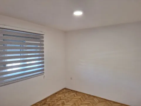 An empty room with parquet flooring and window blinds. - image 10