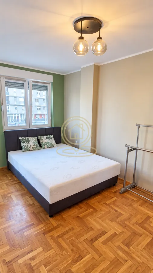 Bedroom with a double bed and parquet flooring.