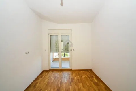 Prazna soba sa drvenim parketom i balkonskim vratima. - image 4