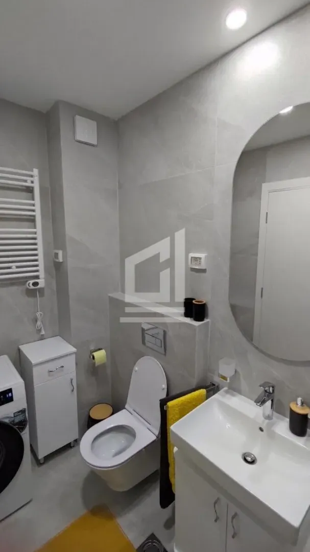 Modern bathroom equipped with a washbasin, toilet, and washing machine.