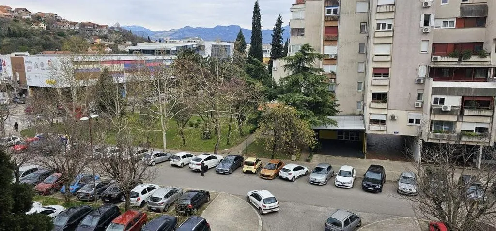 Pogled iz stana na parking i okolne zgrade.
