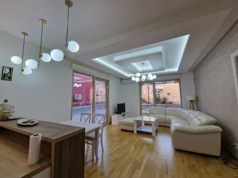 Spacious living room with a sectional sofa, dining area, and a drop ceiling with lighting. - image 10
