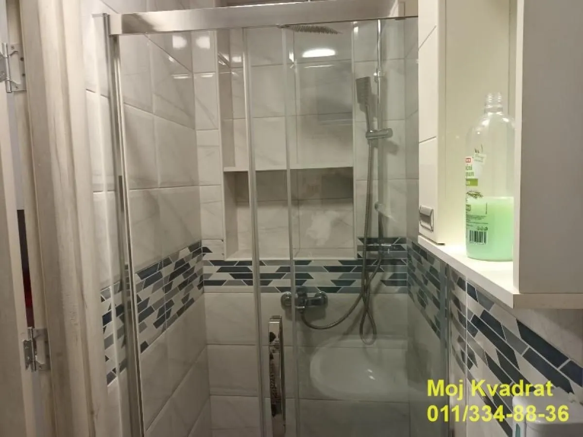 View of the shower cabin in a tiled bathroom.