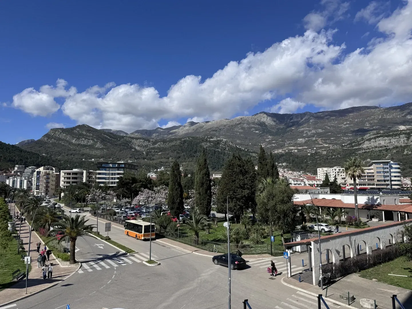 Pogled iz objekta na okolne ulice, park i planine u pozadini.