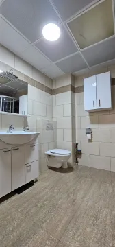 Potpuno opremljeno kupatilo sa svijetlim pločicama, umivaonikom i toaletom. - image 7