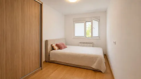 Manja spavaća soba sa krevetom i ugrađenim ormanom. - image 9