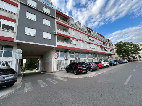 Pogled na spoljašnjost stambene zgrade sa parkingom ispred. - image 4