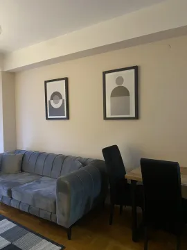 Living room with a grey sofa and a dining table. - image 12