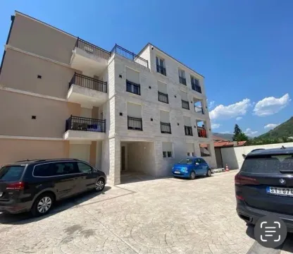 Exterior of an apartment building with a yard and parking area. - image 15