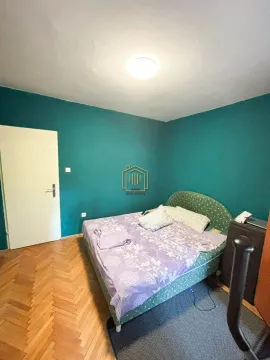Spavaća soba sa bračnim krevetom i zelenim zidom. - image 18