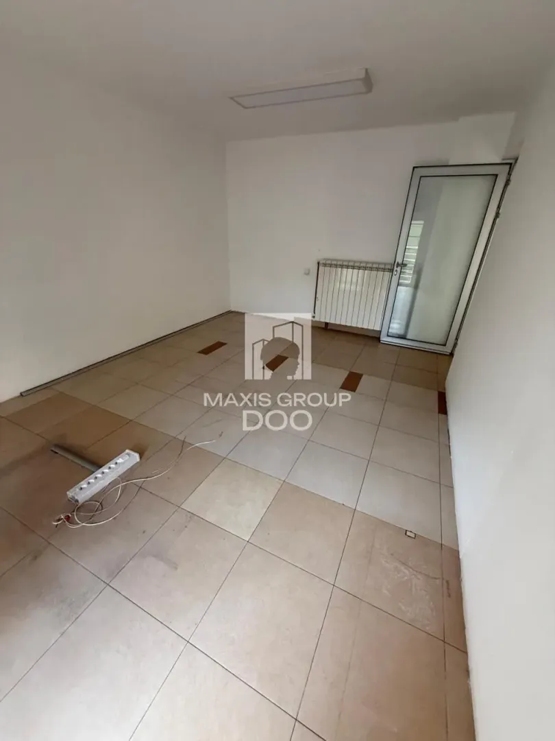 Empty room with ceramic floor tiles and a door.