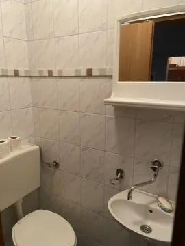 A small bathroom featuring a sink, mirror, and toilet. - image 6
