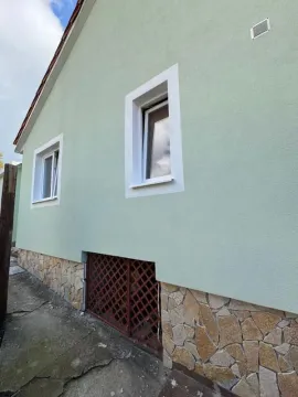 Bočna fasada kuće sa svijetlozelenom fasadom, kamenim podrumskim dijelom i prozorima. - image 9