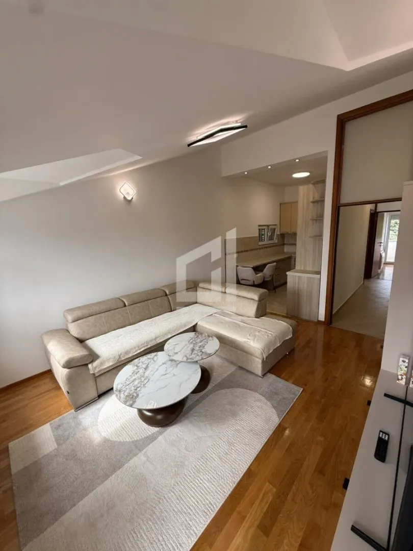 Living room with a sofa and a small coffee table, with a view of the kitchen and hallway.