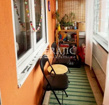 Enclosed balcony with chairs and shelving. - image 8
