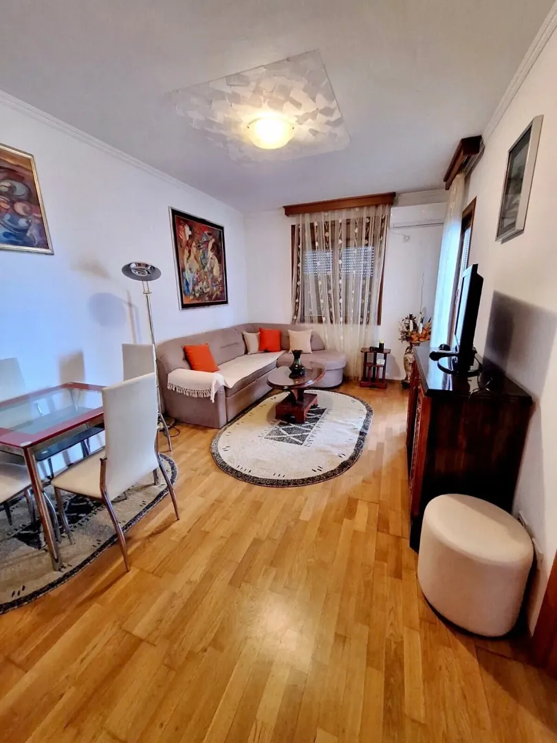 Spacious living room with a sofa set, dining table and hardwood flooring.
